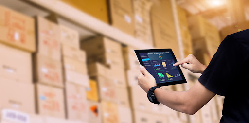 A warehouse manager uses a tablet to align supply chain activities with corporate strategy
