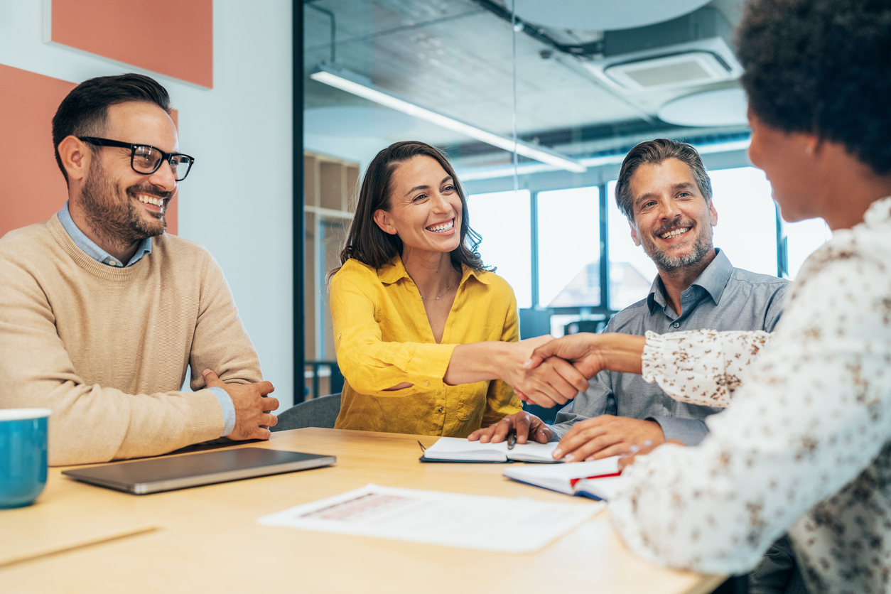Team meeting with 2 women shaking hands