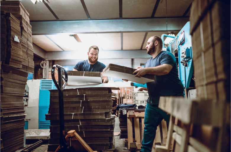 Two men stack boxes as part of a company’s on-demand labor strategy.